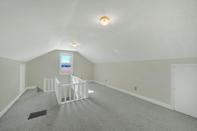 bonus room with light colored carpet and lofted ceiling