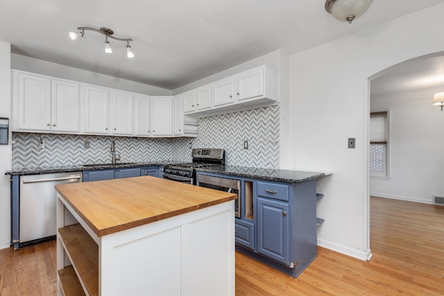 kitchen featuring blue cabinetry, sink, a center island, appliances with stainless steel finishes, and white cabinets