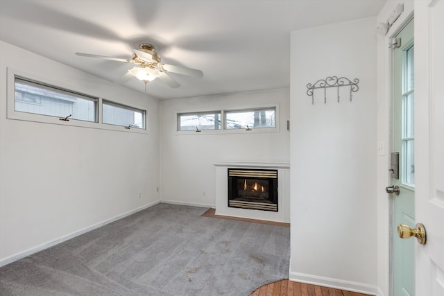 unfurnished living room featuring ceiling fan and light carpet