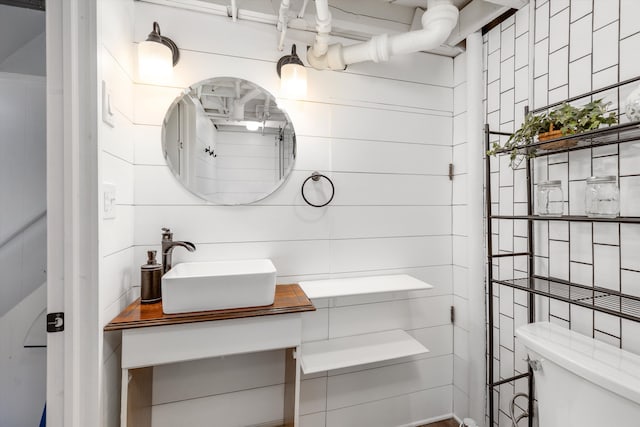 bathroom with vanity, tile walls, and toilet