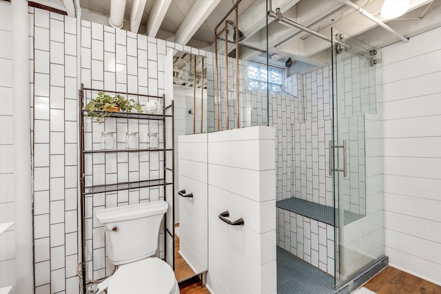 bathroom featuring toilet, an enclosed shower, hardwood / wood-style floors, and tile walls