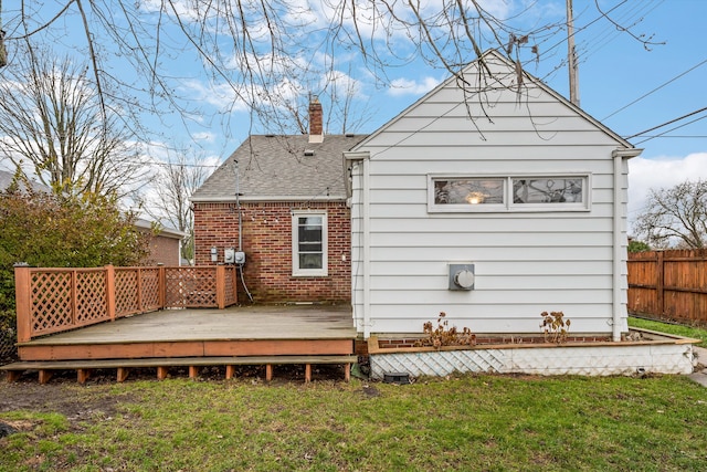 rear view of house featuring a wooden deck and a yard