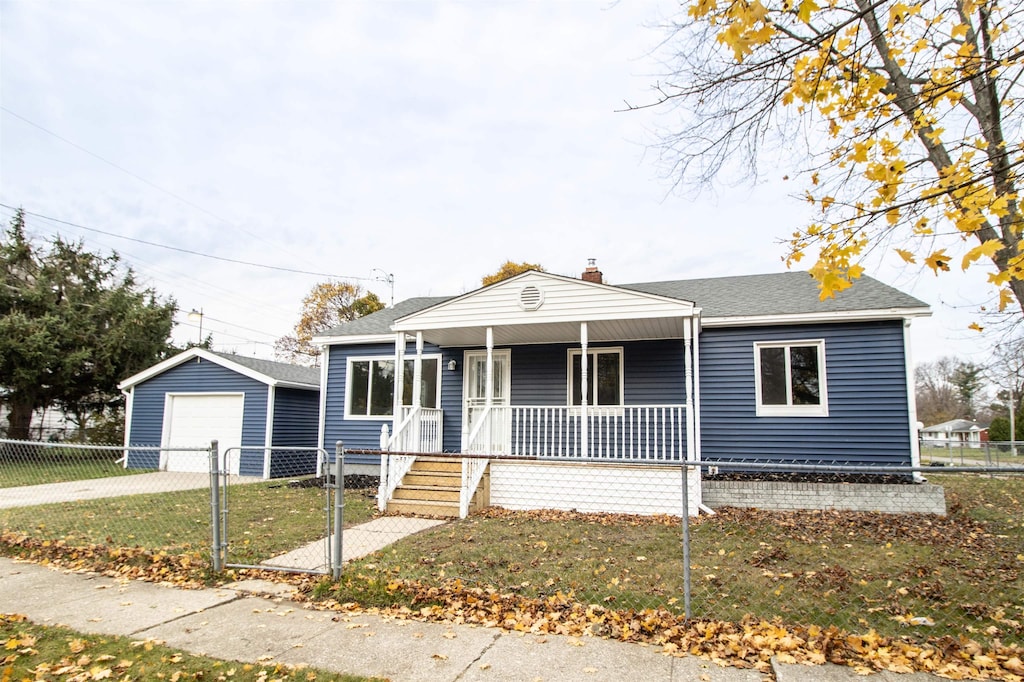 view of front of house featuring a garage, covered porch, an outdoor structure, and a front yard