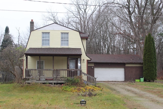 view of front of home featuring covered porch, a garage, and a front yard