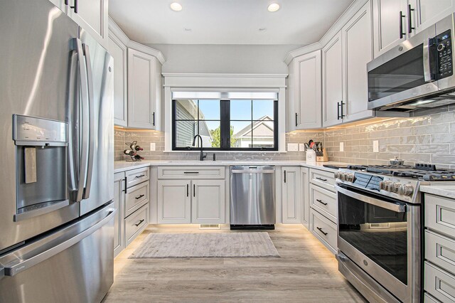 5405 Harborview Pass, Kalamazoo, MI 49009 - kitchen with appliances with stainless steel finishes, a sink, backsplash, recessed lighting, and white cabinetry