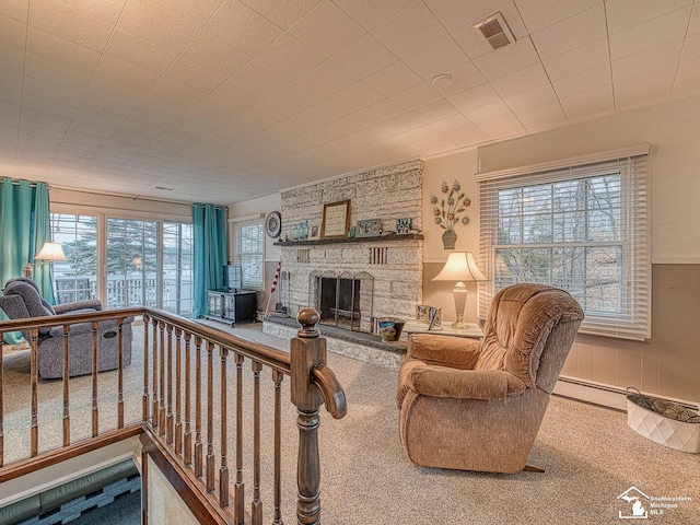 11477 Highland Hills Dr, Jerome, MI 49249 - carpeted living area featuring plenty of natural light, a baseboard radiator, a stone fireplace, and wainscoting