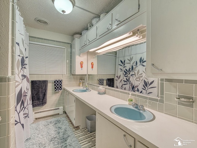 11477 Highland Hills Dr, Jerome, MI 49249 - bathroom featuring a baseboard heating unit, double vanity, tile walls, and tasteful backsplash