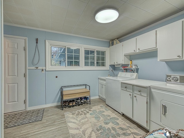 11477 Highland Hills Dr, Jerome, MI 49249 - laundry area featuring cabinet space, ornamental molding, separate washer and dryer, light wood-type flooring, and baseboards