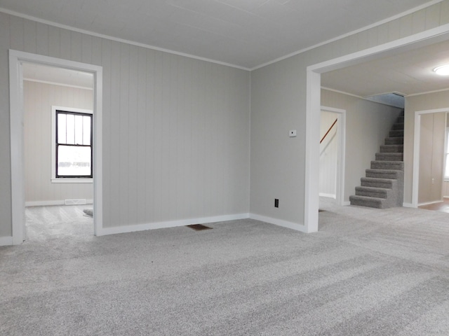 empty room featuring light colored carpet and ornamental molding