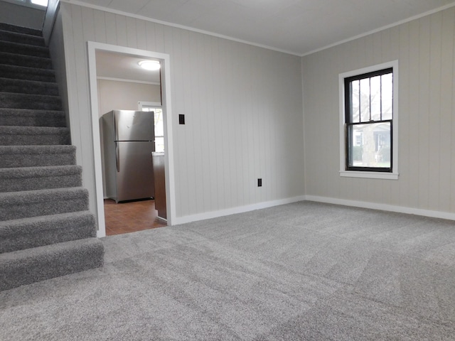 empty room featuring carpet flooring and crown molding