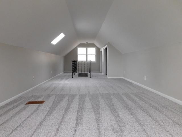 additional living space featuring carpet floors and vaulted ceiling