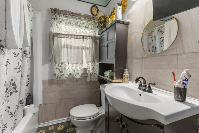 full bathroom featuring vanity, toilet, shower / bath combo with shower curtain, and tile walls