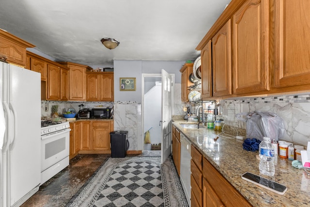 kitchen featuring light stone countertops, sink, and white appliances