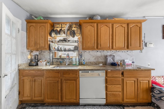 kitchen with white dishwasher, tasteful backsplash, and sink