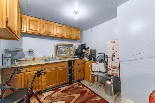 kitchen with light stone countertops, light tile patterned floors, and sink