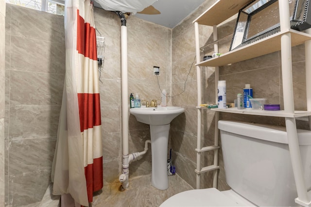 bathroom with tile walls and toilet