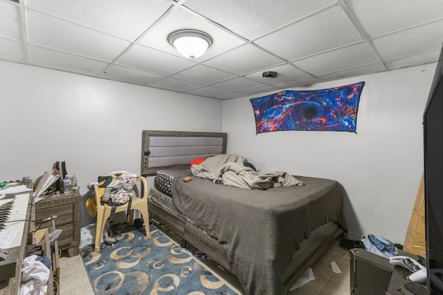 bedroom with a paneled ceiling and wood-type flooring