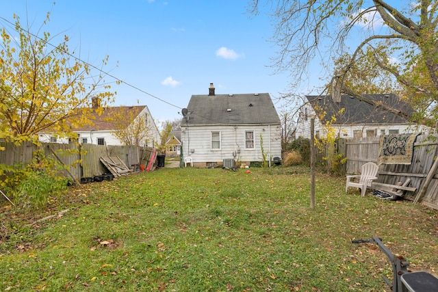 back of house with a lawn and central AC