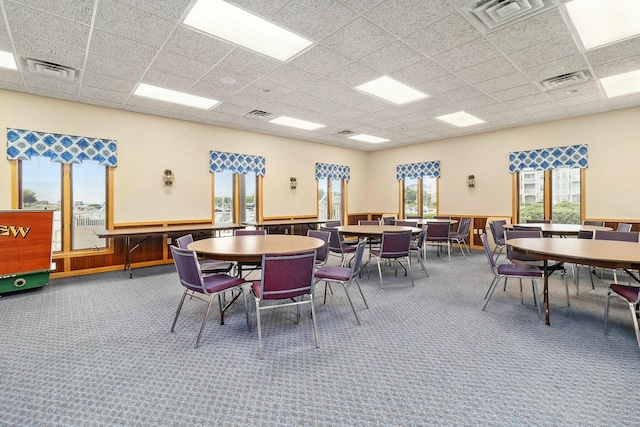 dining space featuring carpet and a drop ceiling