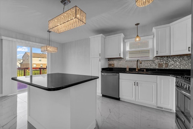 kitchen featuring stainless steel appliances, sink, a notable chandelier, white cabinets, and a kitchen island