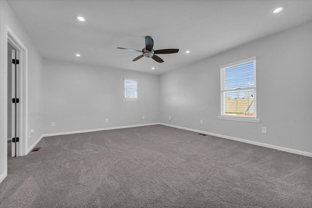 carpeted spare room with ceiling fan and a healthy amount of sunlight