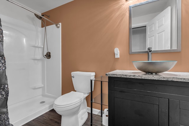 bathroom with a shower with curtain, vanity, hardwood / wood-style flooring, and toilet