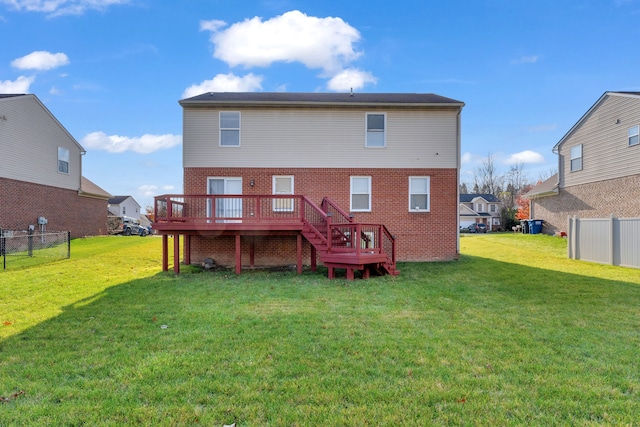 rear view of house with a deck and a lawn