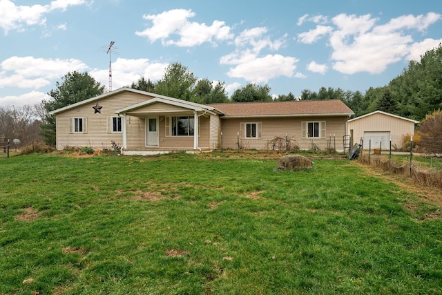 view of front facade with a front yard, a garage, an outdoor structure, and covered porch