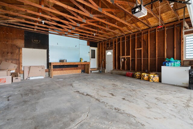 garage with a garage door opener and white refrigerator