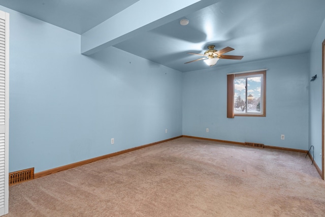 unfurnished room featuring light carpet, ceiling fan, and beamed ceiling