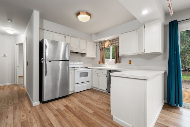 kitchen featuring appliances with stainless steel finishes, light wood-type flooring, and white cabinetry