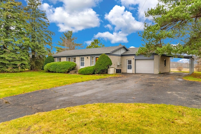 single story home featuring a carport, a garage, and a front lawn