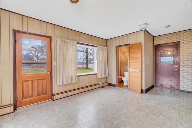 interior space featuring wood walls, brick wall, and a baseboard radiator