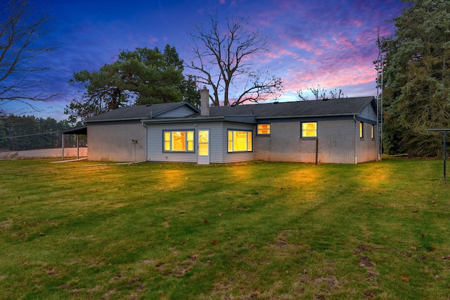 back house at dusk featuring a yard