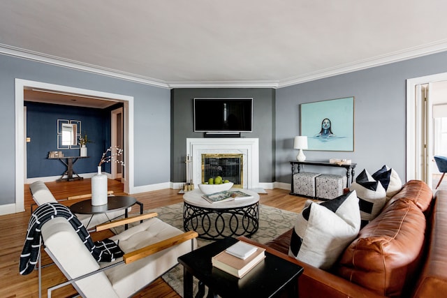 living room featuring wood-type flooring, ornamental molding, and a high end fireplace