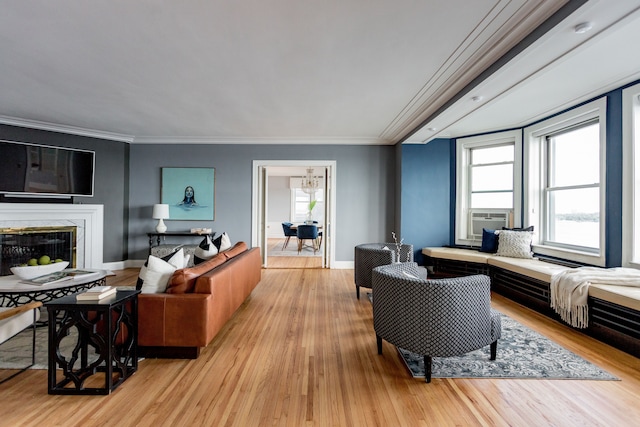 living room with a healthy amount of sunlight, crown molding, and light hardwood / wood-style flooring