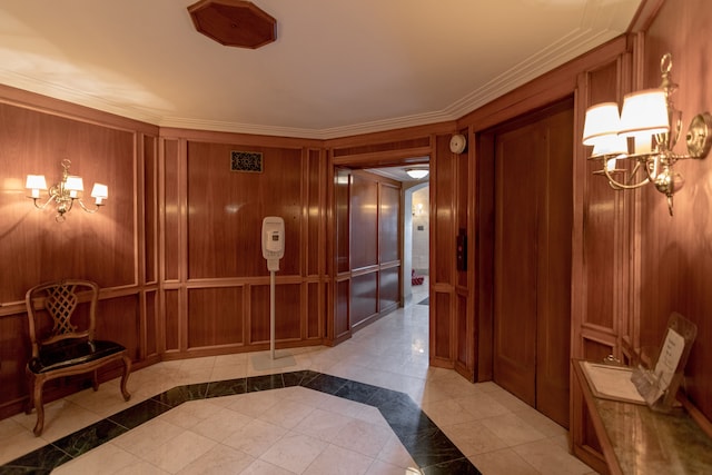 hall featuring an inviting chandelier, crown molding, and wood walls