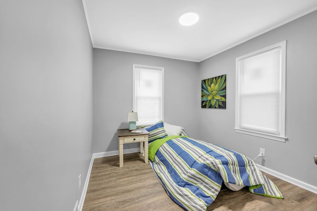 bedroom featuring ornamental molding and light wood-type flooring