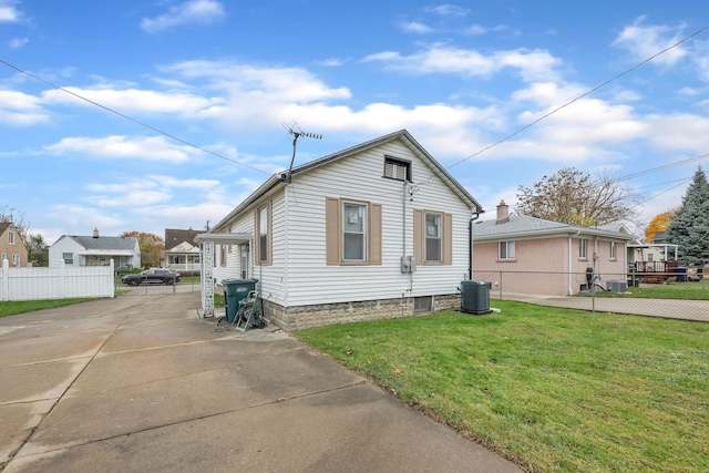 view of front of home with central AC unit and a front lawn