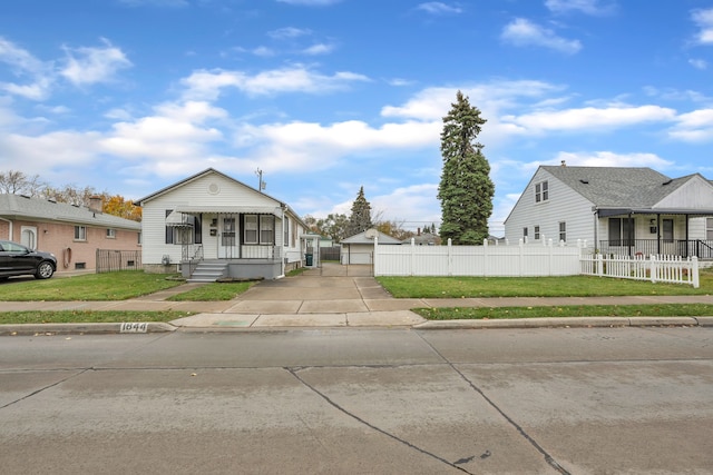 bungalow-style house featuring an outbuilding, a garage, and a front yard