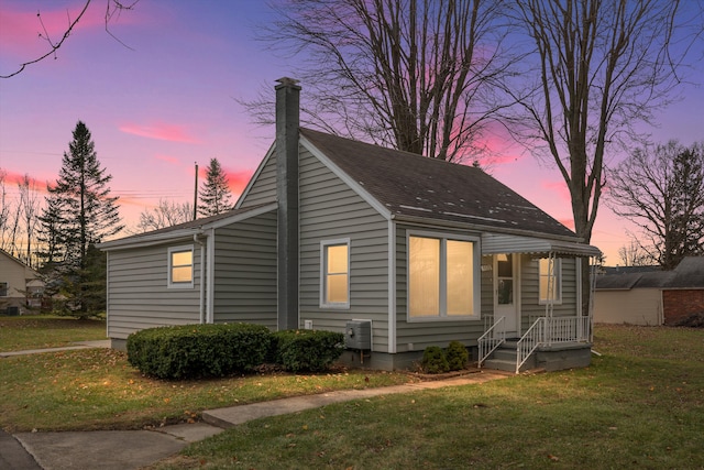 property exterior at dusk featuring central AC and a yard