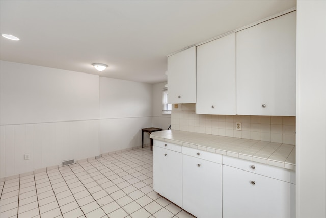5570 Meadow View St, Sterling Heights, MI 48310 - kitchen featuring tile counters, white cabinetry, decorative backsplash, and light tile patterned flooring