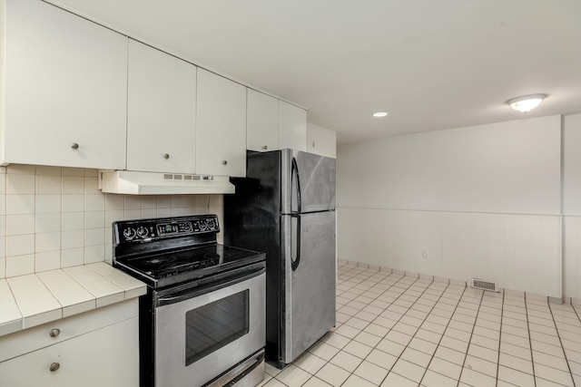 kitchen featuring light tile patterned floors, appliances with stainless steel finishes, tile countertops, and white cabinetry