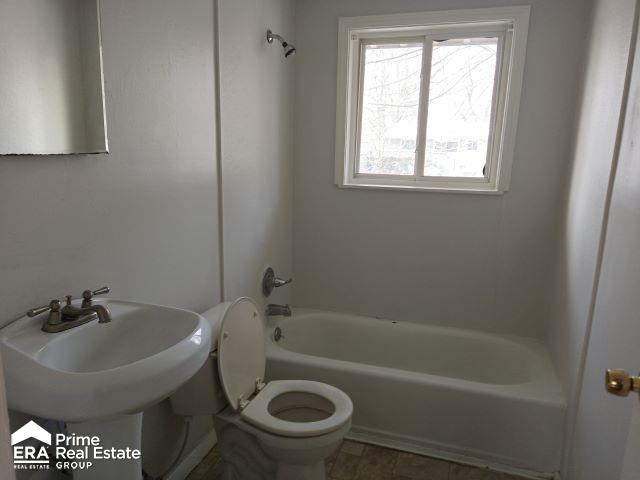 full bathroom featuring sink, washtub / shower combination, and toilet