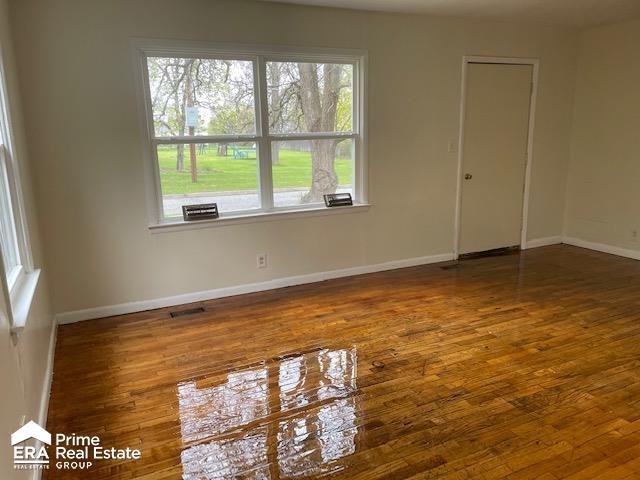 1080 E Cornell Ave, Flint, MI 48505 - spare room featuring wood finished floors, healthy amount of natural light, and baseboards
