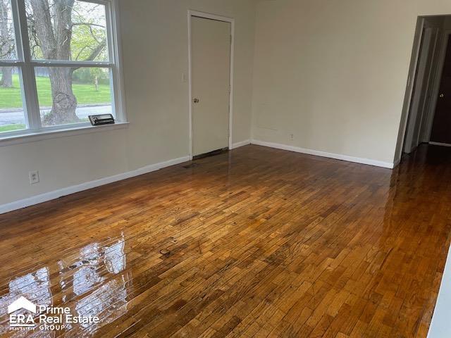 1080 E Cornell Ave, Flint, MI 48505 - spare room with dark wood-style flooring and baseboards
