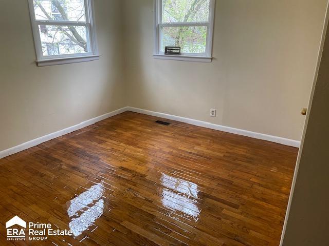 1080 E Cornell Ave, Flint, MI 48505 - spare room featuring plenty of natural light, hardwood / wood-style flooring, and baseboards