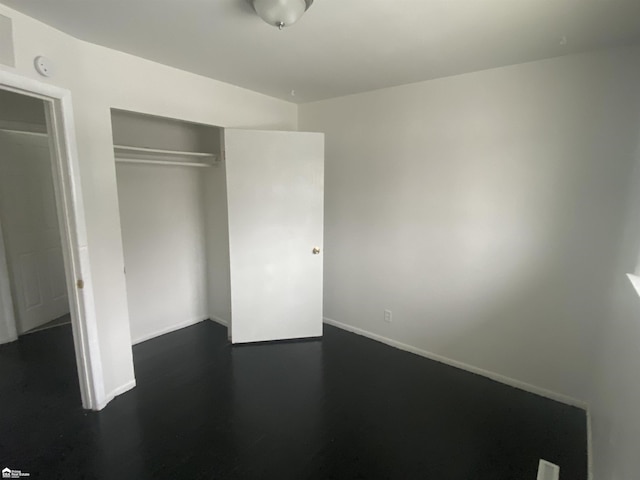 5509 Farmhill Rd, Flint, MI 48505 - unfurnished bedroom with a closet, baseboards, and dark wood finished floors