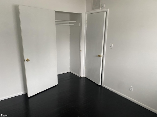 5509 Farmhill Rd, Flint, MI 48505 - unfurnished bedroom with baseboards, a closet, and dark wood-style floors