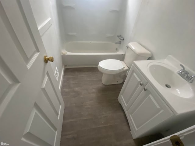 full bathroom featuring hardwood / wood-style floors, vanity, toilet, and bathtub / shower combination